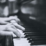 Músico talentoso tocando um piano de cauda em uma sala iluminada