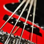 Imagem de um baixo acústico de quatro cordas, um instrumento de cordas com formato distinto e som profundo.