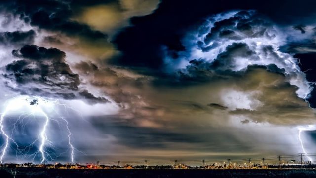 O que a Bíblia diz sobre as tempestades da vida. Tempestade intensa com céu escuro, nuvens negras, trovoadas e raios durante uma forte chuva, simbolizando desafios e superação.
