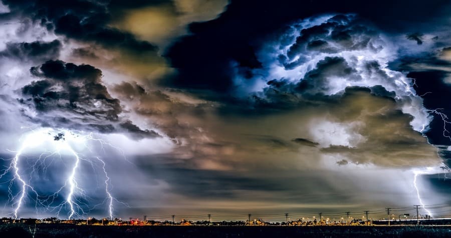 O que a Bíblia diz sobre as tempestades da vida. Tempestade intensa com céu escuro, nuvens negras, trovoadas e raios durante uma forte chuva, simbolizando desafios e superação.